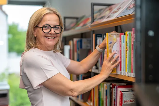 Mitarbeiterin der Gemeindebücherei Obersulm am Bücherregal